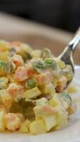Olivier salad fork Traditional salad Olivier. Christmas and New year food. White plat with fork and knife with copy space. Top view, flat lay. Microgreen, quail eggs. Serving at a restaurant. video