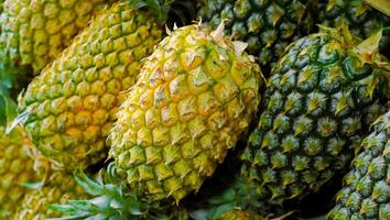 Piles of fresh pineapples for sale at the market, seen from above Free Photo