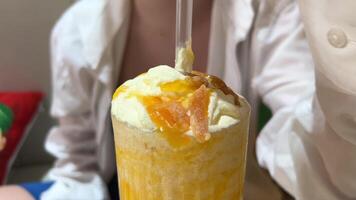 mango smoothie vibrant and creamy mango smoothie served in a tall glass, topped with fresh mango slices and a black straw. A refreshing tropical drink perfect for summer vibes. video