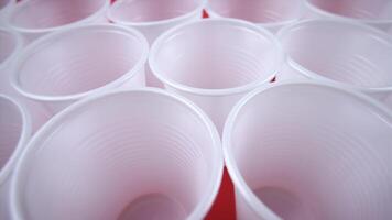 empty white disposable cups stand on red background closeup video