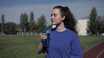 Fitness girl drinking water after workout. Athletic girl Drink water video