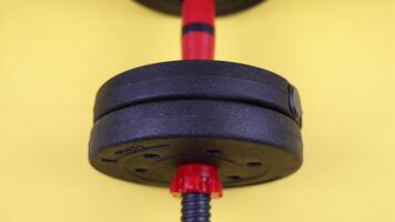 Dumbbell with gym weights on yellow background video