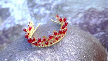 Red crown for the head on the stone in the stream of water video