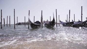 waves roll on stone pier while empty gondolas swing on water video