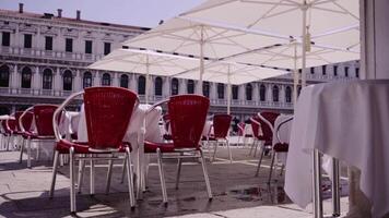cafe with tables and umbrellas near old building in Venice video