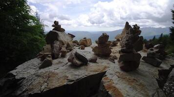 Stacks of rocks on stone near forest against sky with clouds video