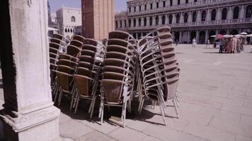 stacks of armchairs on St. Mark square near ancient building video