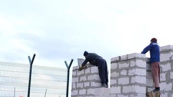 Building a house. Workers lay bricks, gluing them with cement video