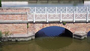 empty vintage bridge with white railings over calm river video