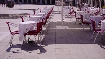 Kafé med rader av eleganta tabeller och röd stolar på fyrkant video