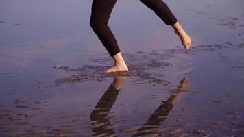 Barefoot ballet dancer shows classic exercises in water video