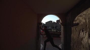 Dancer silhouette performs between old building walls video