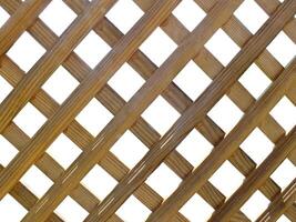 Grid of wooden fence isolate on white background. Seamless light brown grid wood lattice texture cut out. photo