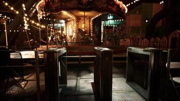 Empty amusement park at night with illuminated carousel and turnstiles video
