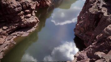 Reflections of clouds on the tranquil Colorado River in a rocky canyon video