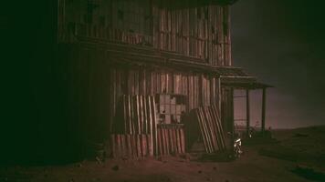 Old wooden barn structure on a desolate landscape during twilight hours video