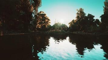 Tranquil riverside view at sunset with reflections in clear water video