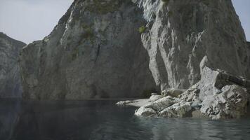 Rocky cliffs and calm waters at dusk along a serene lake shoreline video