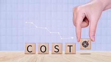 Cost reduction concept on wooden cube, Expenses and saving money, Business strategy and project management, cost reduction, efficient business and budget cutting. photo