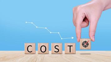 Cost reduction concept on wooden cube, Expenses and saving money, Business strategy and project management, cost reduction, efficient business and budget cutting. photo