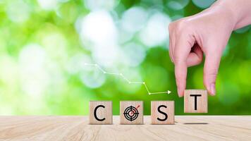 Cost reduction concept on wooden cube, Expenses and saving money, Business strategy and project management, cost reduction, efficient business and budget cutting. photo