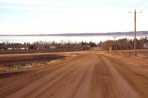 A dirt road with a power pole in the middle photo