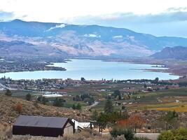 A view of a lake and mountains from a hill photo