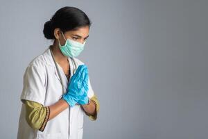 Young woman Doctor doing Namaste because of outbreak of COVID-19. New greeting to avoid the spread of coronavirus instead of greeting with a hug or handshake. photo
