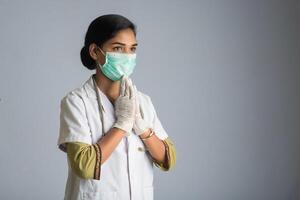 Young woman Doctor doing Namaste because of outbreak of COVID-19. New greeting to avoid the spread of coronavirus instead of greeting with a hug or handshake. photo