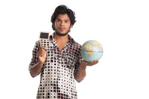 young man holding a world globe and a small board on a white background. photo