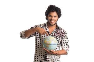 young man with a world globe on a white background. photo