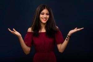 Portrait of beautiful young girl presenting something, showing copy space on her palm on a grey background photo