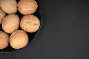 Walnut black plate in corner side with black background photo