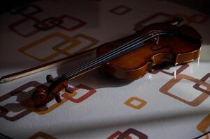 Elegant violin resting on a patterned table in soft light photo