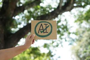 Close up hand holds paper card with drawn sign AI in circle and tick mark. Concept, Choose ,agree and accept to use AI or Artificial Intelligence to apply in daily life. photo