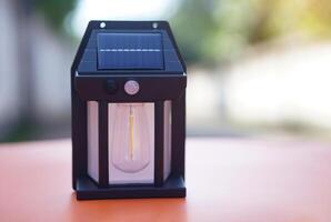 Mini lantern with solar panel. Concept, electrical equipment, generate electricity by solar panel for light in darkness at night. Natural power from sunlight. Clean energy for environment. photo