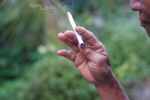 Close up man is smoking cigarette. Concept, smoking is bad for health. Private favorite for relaxation but can cause health problems respiratory disease and addict. photo