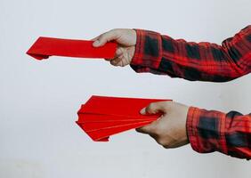 Hand holding red packet or red envelope isolated on white background. Chinese New Year or Lunar New Year concept. photo