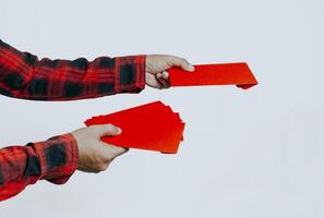 Hand holding red packet or red envelope isolated on white background. Chinese New Year or Lunar New Year concept. photo