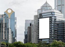 Mock up white vertical large LED display billboard on tower building with cityscape background .Clipping path for mockup photo