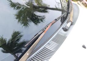 Old wipe retro car with rust on it and coconut tree reflect on windscreen. photo