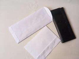 black wallet and rectangular paper envelope isolate on white photo
