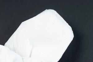 Folded White Napkin or tissue paper isolated on black background side view of a formal dining table setting photo