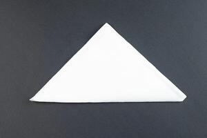 Folded White Napkin or tissue paper isolated on black background top view of a formal dining table setting photo
