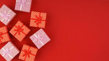Red and pink gift boxes on red background with copy space. photo