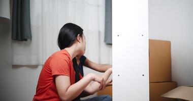 Handheld shot, Two siblings are happily chatting while assembling furniture together in the living room of their new house. Moving to a new home concept video