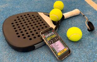 paddel racket and smartphone with bet background photo