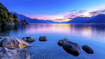 A tranquil lake scene at sunrise, featuring calm water reflecting the vibrant colors of the sky. photo
