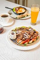Fruit crepes with chocolate and maple syrup for breakfast photo