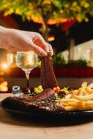 Lunch featuring a steak filet, salad, and French fries, elegantly presented on a table. photo
